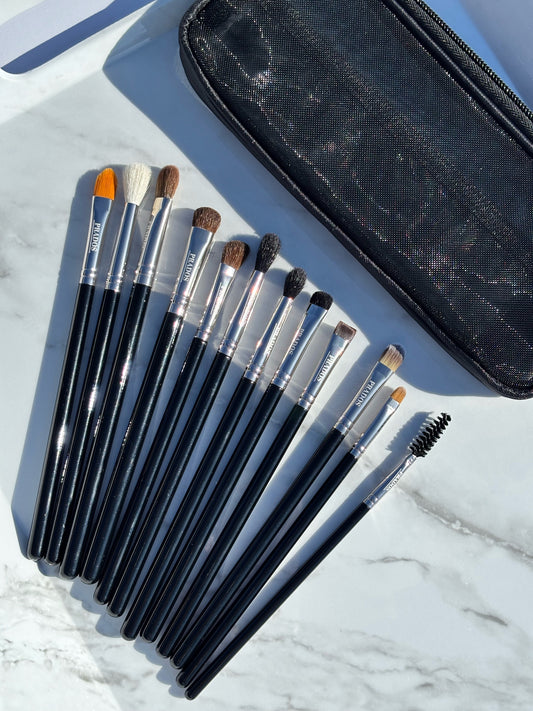 Set of makeup brushes with a black case on a marble surface