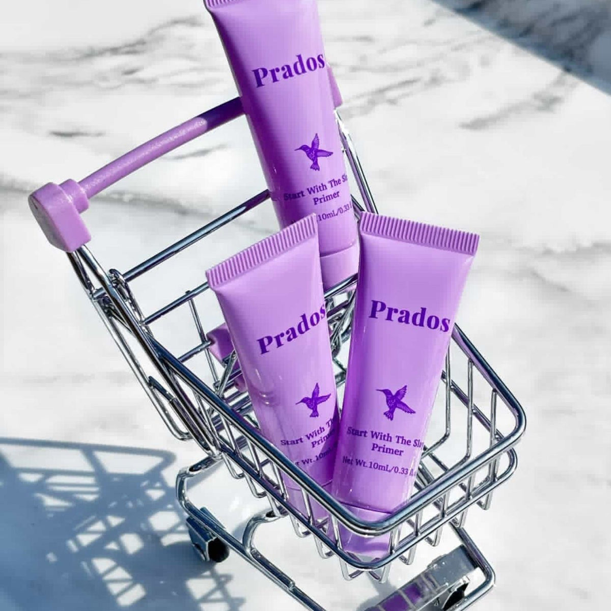 Purple 'Prados' skincare products in a small shopping cart on a light background