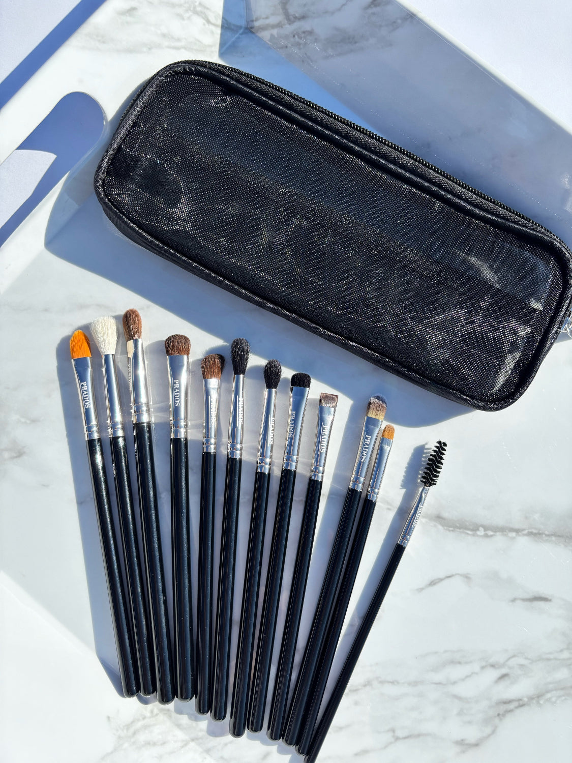 Set of makeup brushes with a black case on a marble surface