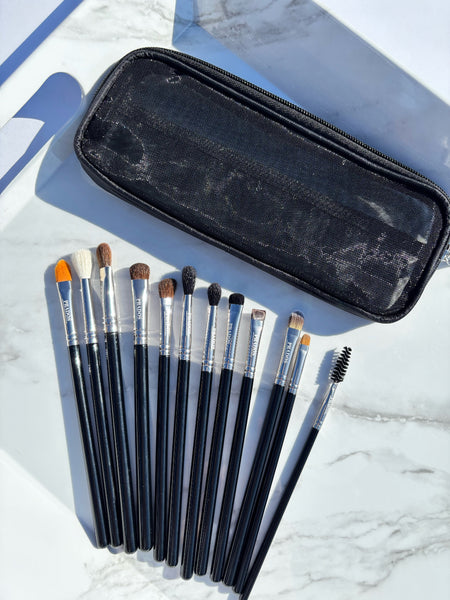 Set of makeup brushes with a black case on a marble surface
