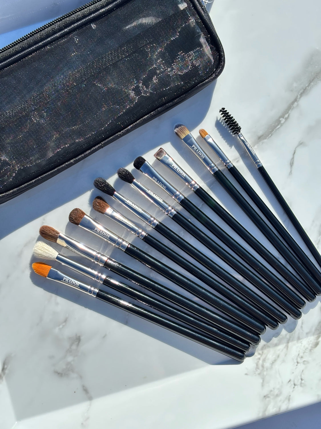 Set of makeup brushes with a black case on a marble surface